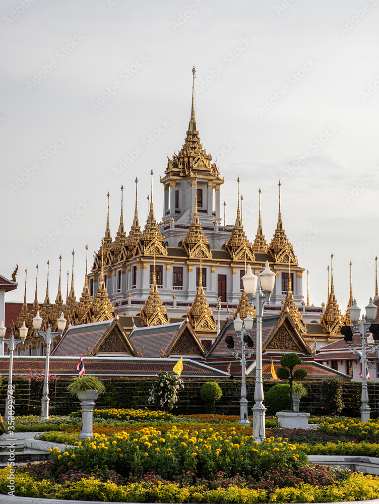  Wat Ratchanatdaram Woravihara (Loha Prasat) with yellow flowers during coronation celebrations of His Majesty King Maha Vajiralongkorn Bodindradebayavarangkun (King Rama X), Bangkok, Thailand