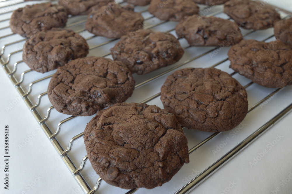 Fototapeta premium Closeup homemade round chocolate cookies on cake cooler with blurred background in kitchen