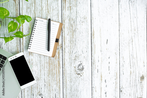 Flat lay photo of office desk with laptop, smartphone, and notebook with copy space background. wooden backgrond.