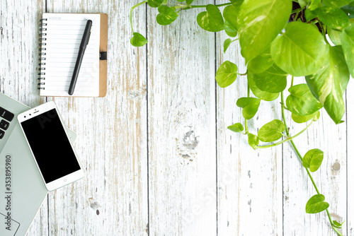 Flat lay photo of office desk with laptop, smartphone, and notebook with copy space background. wooden backgrond.