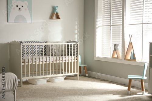 Cute baby room interior with crib and decor elements