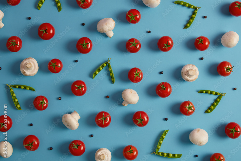 Fresh vegetables, ingredients for cooking soup or salad. Champignons, red tomatoes, green peas and peppercorns on blue background. Healthy food, nutrient products. Selective focus, above shot