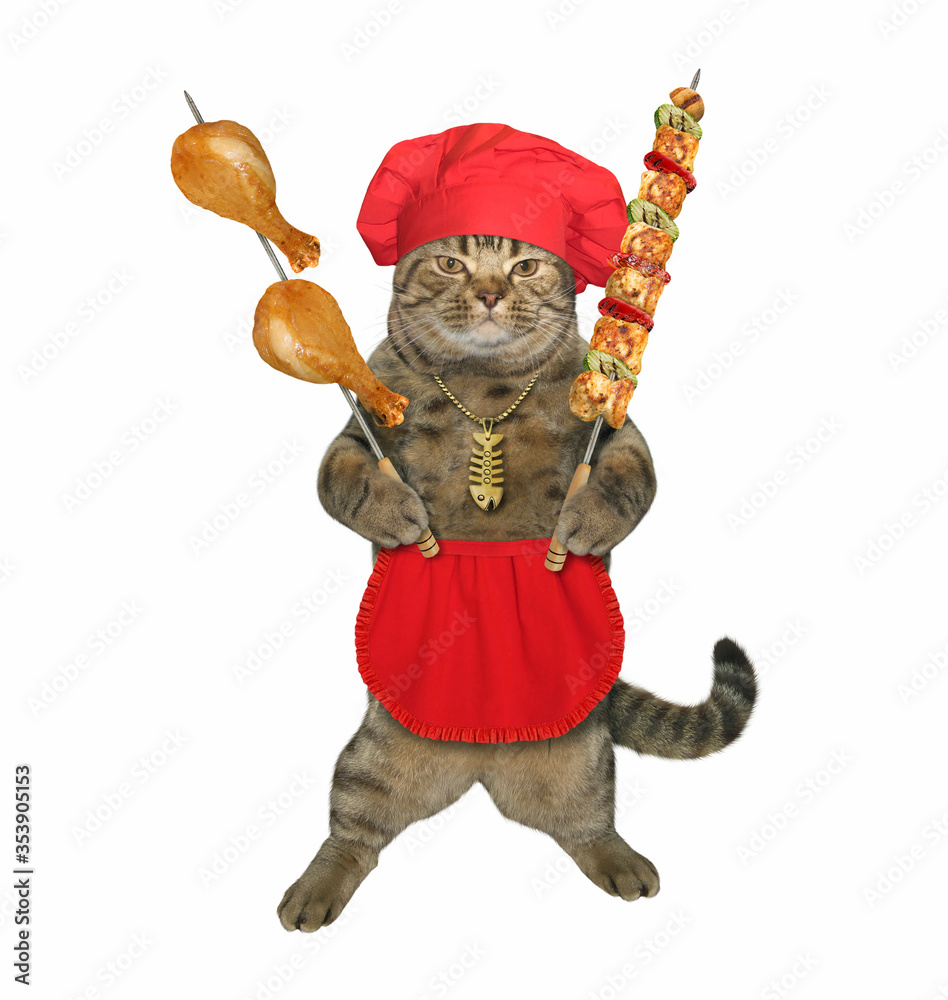 The beige cat in red cook uniform with a gold fish-bone pendant is holding two steel skewers with grill meat. White background. Isolated. The beige cat in red cook uniform with a gold fish-bone pendant is holding two steel skewers with grill meat. White background. Isolated.