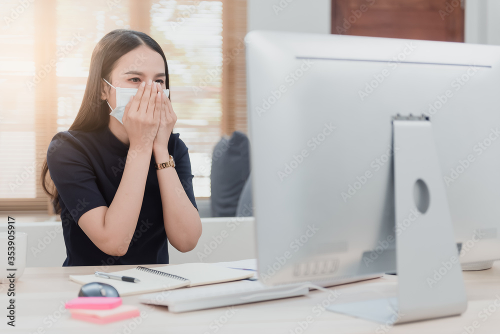 Asian woman is working from home. With illnesses with respiratory diseases Put on a medical mask, coughing in front of a computer. Asian woman is working from home. With illnesses with respiratory diseases Put on a medical mask, coughing in front of a computer.