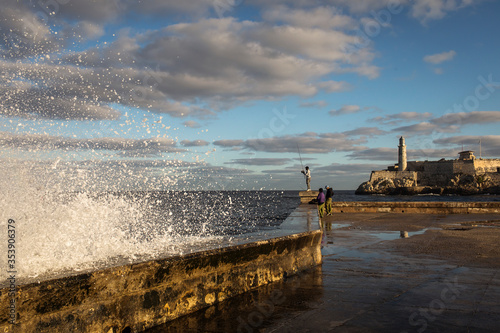 Big waves on Malecon streets during sunrise with storm clouds in background. Havana  Cuba