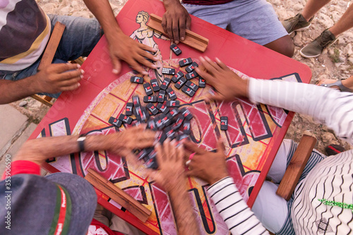 Photography Peoples hand on a table playing domino in the street of Trinidad, Cuba