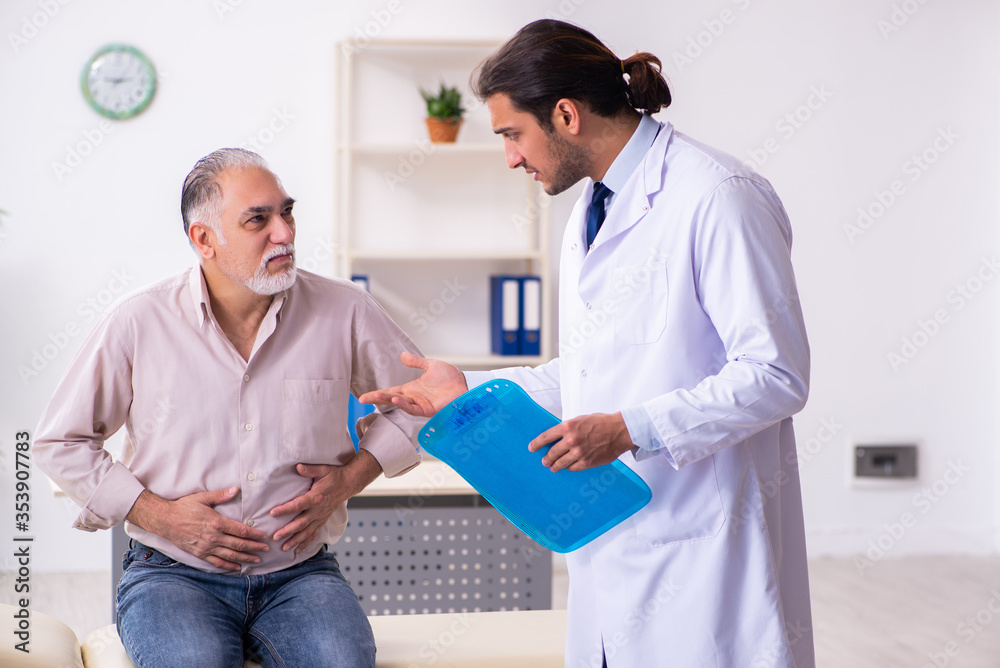 Old patient visiting young male doctor Old patient visiting young male doctor