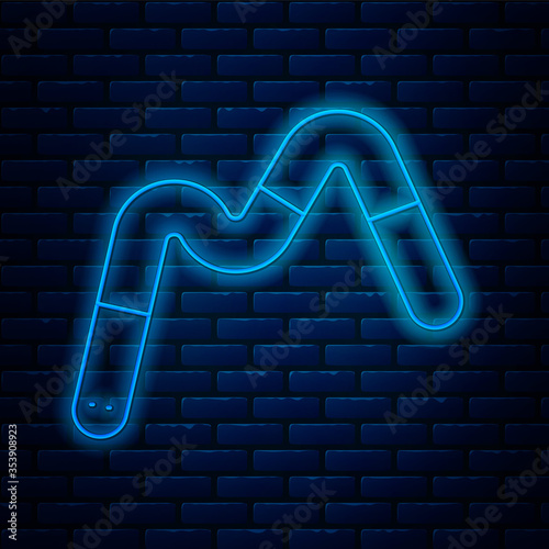 Glowing neon line Jelly worms candy icon isolated on brick wall background. Vector.