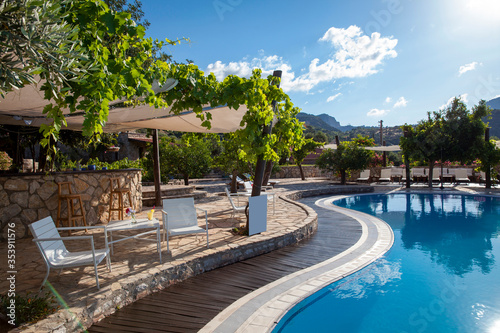 backyard of a hotel with a swimming pool and great mountain view. © Cumhur