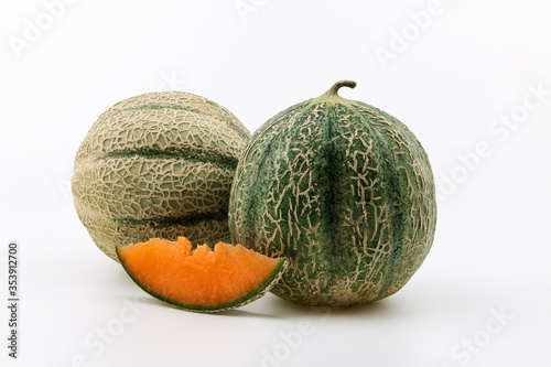 Fresh round melon with a cut piece on the white background