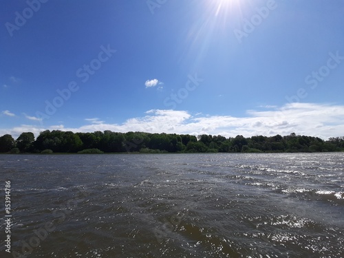Lake with waves against the background of an ancient park
