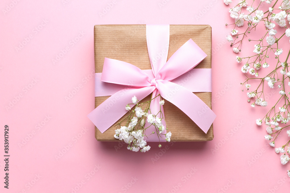 Baby's breath flowers and a gift box with a pink ribbon on a pink background, close-up. Wedding design, greetings, invitations, Wallpapers. Baby's breath flowers and a gift box with a pink ribbon on a pink background, close-up. Wedding design, greetings, invitations, Wallpapers.