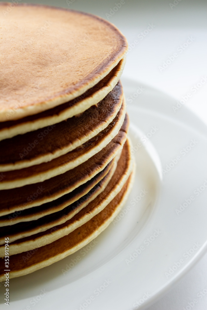 Pancakes on a white plate close-up on a light background Pancakes on a white plate close-up on a light background