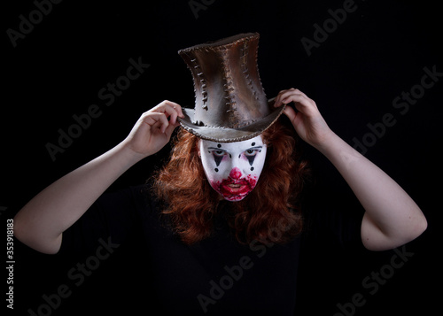Young woman in scary, horror, clown make up wearing a home made Top Hat.