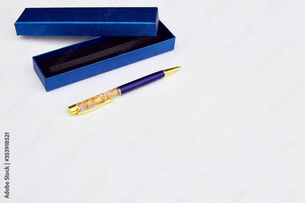 one pen and a blue gift box for a pen close-up, on a gray background, copy space, stack of cards one pen and a blue gift box for a pen close-up, on a gray background, copy space, stack of cards