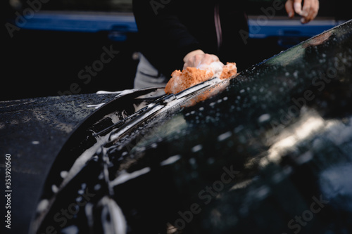 Fotografía myjnia, mycie samochodu, mężczyzna myje swój samochód