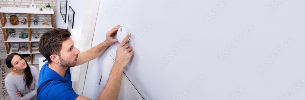 Repairman Installing Smoke Detector On Wall Repairman Installing Smoke Detector On Wall