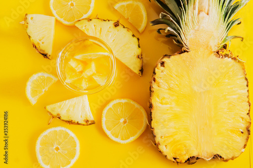 Pineapple and lemon on a yellow background in a cut photo