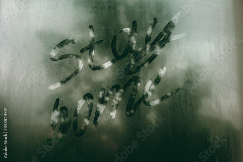 The inscription "stay home" on the foggy window. Cloudy and rainy weather. 