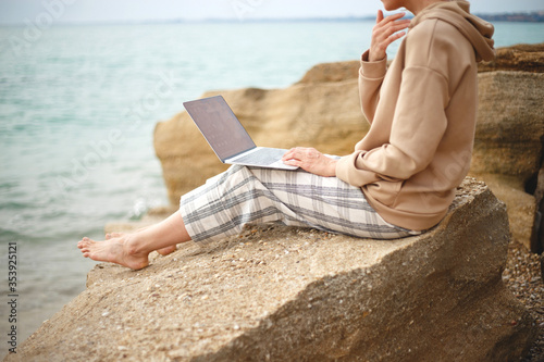 girl with a laptop by the sea. remote work concept