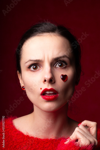 beautiful woman in red with rhinestones on her face