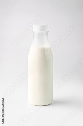 food photography of clean white sterile plastic bottle of natural dairy product close-up on a light gray background isolated