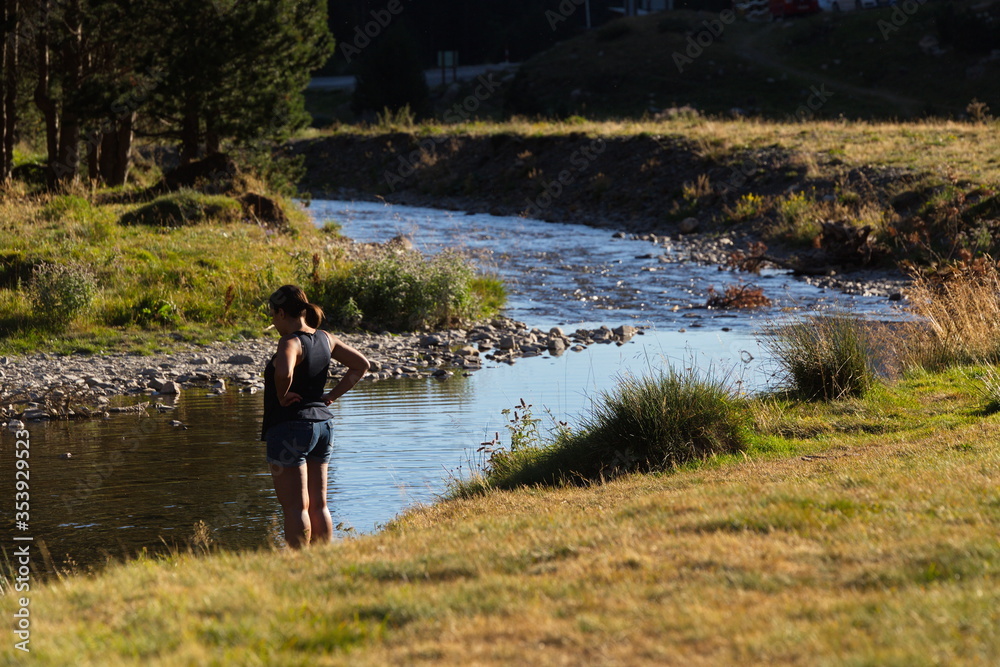 Llanos del hospital, Huesca/Spain; Aug. 21, 2017. A woman relaxes by the river. Place called Llanos del Hospital belonging to the municipality of Benasque in the heart of the Pyrenees.