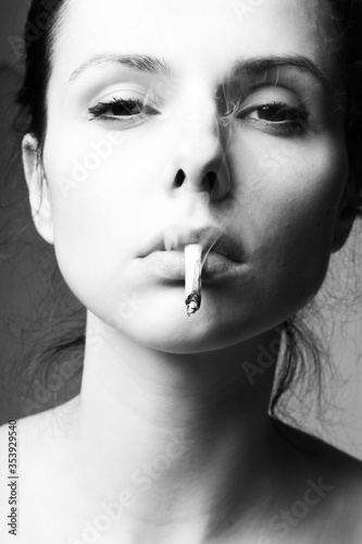 beautiful young brunette woman smokes a cigarette
