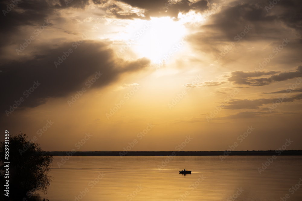sunset on a lake with a passing boat