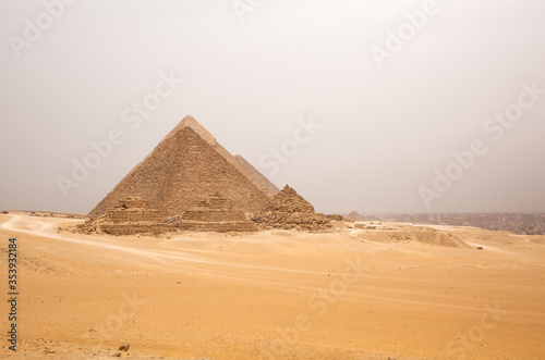 The beautiful pyramids of Giza and the Giza town at the backdrop