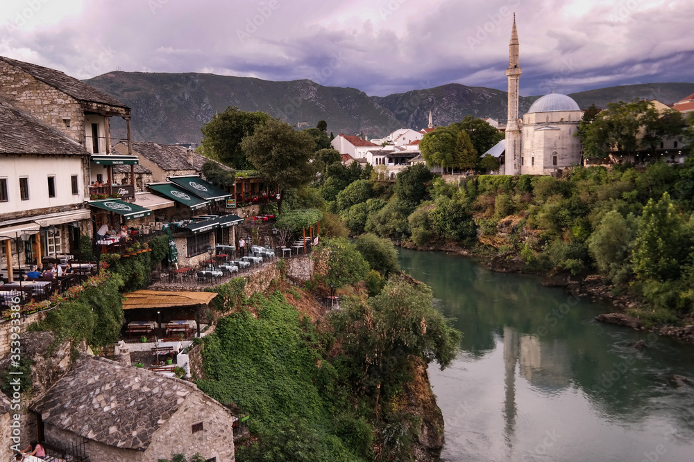 Panorama miasteczka Mostar w Bośni i Hercegowinie nad rzeką Neretwą wraz z meczetami, wzgórzami , rstauracjami i kamiennymi domami