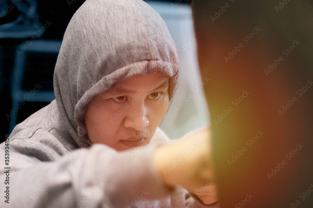 Asian woman boxer hitting punching bag, workout at home gym, female practice martial arts self-defense, boxing cardio exercise Asian woman boxer hitting punching bag, workout at home gym, female practice martial arts self-defense, boxing cardio exercise