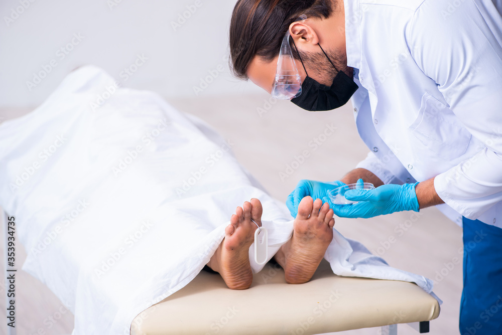 Police coroner examining dead body corpse in morgue Police coroner examining dead body corpse in morgue