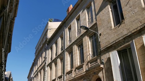 Typical ancient houses on narrow street in center of city south of France with aligned windows.