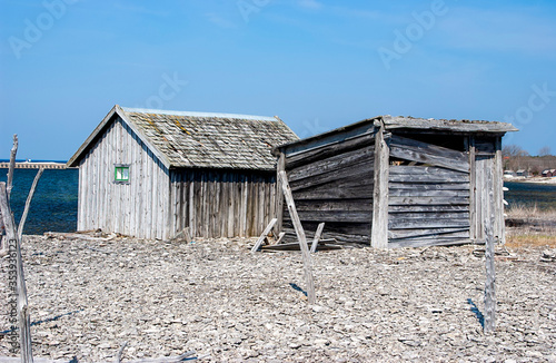 Old wooden cottages on cobblestone beach, Sweden photo