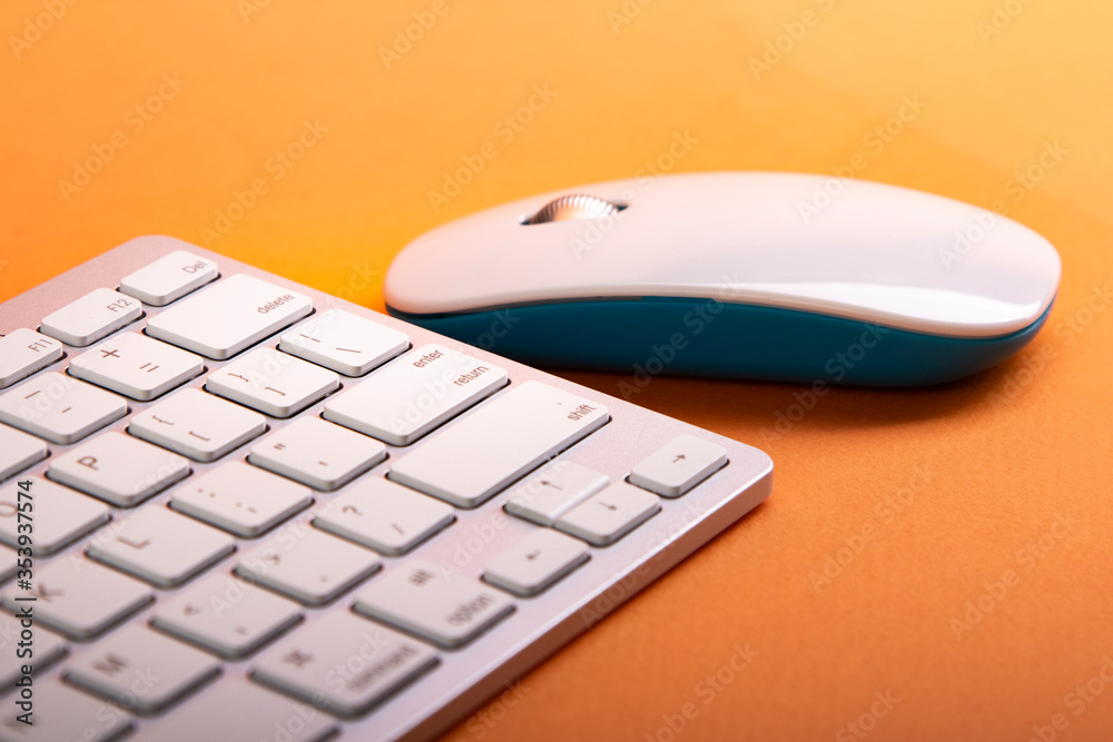 White Keyboard and Mouse on a orange table White Keyboard and Mouse on a orange table