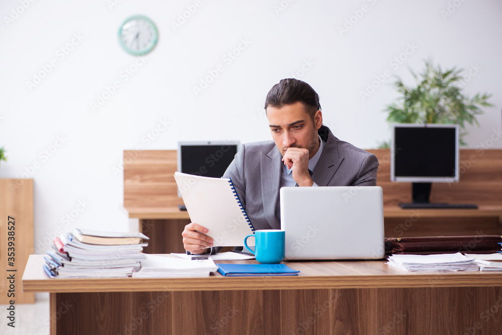 Young male employee unhappy with excessive work Young male employee unhappy with excessive work