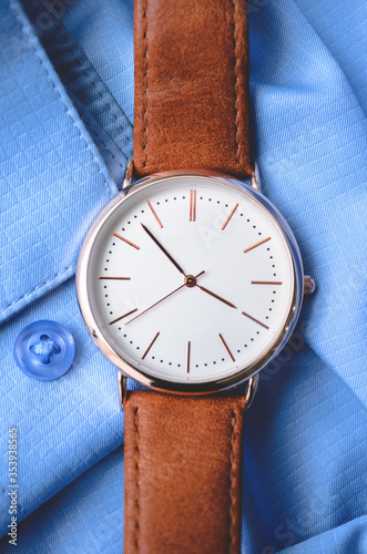 Elegant leather wristwatch on a blue shirt. For business