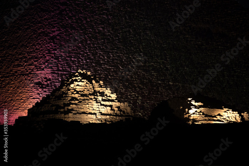 The illuminated great Pyramid and the pyramids of Queen Henutsen and  Queen Meritetis photo