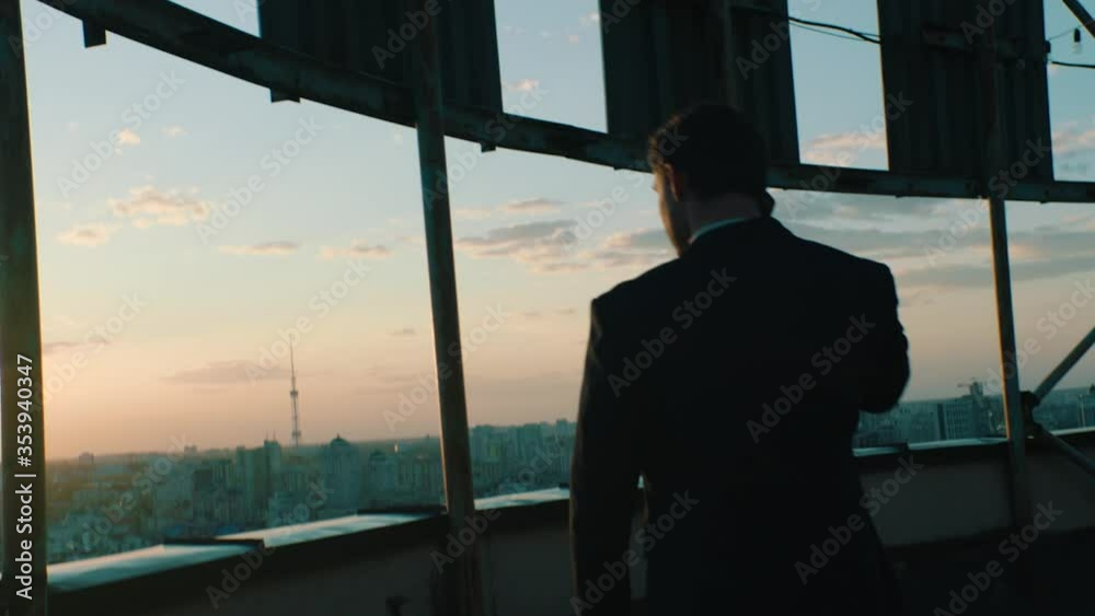 top manager talking on the phone on the roof of a skyscraper top manager talking on the phone on the roof of a skyscraper