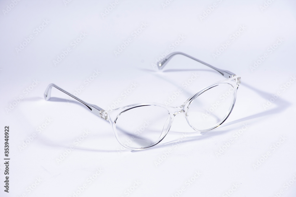 Lentes transparentes con patas de metal sobre fondo blanco Lentes transparentes con patas de metal sobre fondo blanco