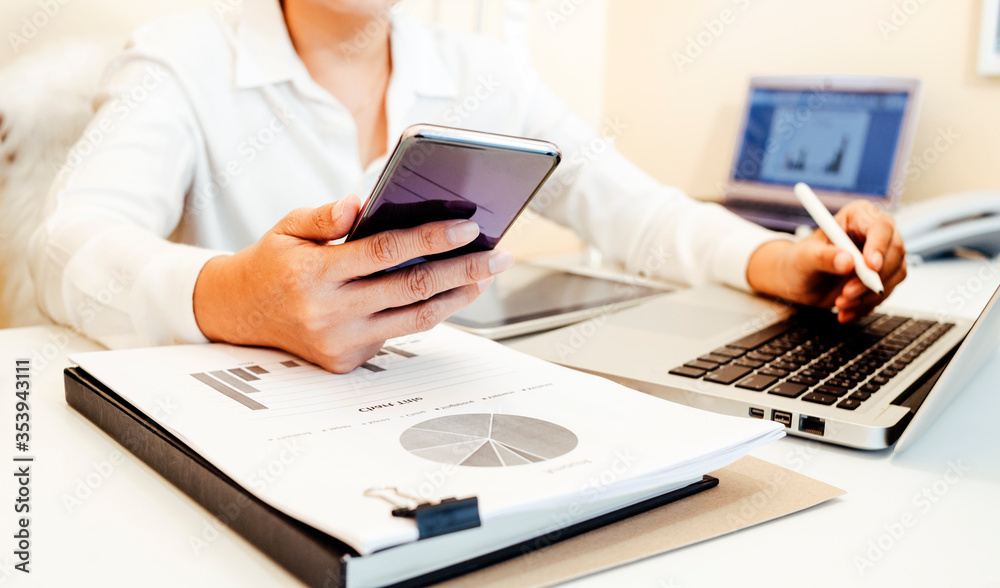 Businesswoman hands working with finances about cost and calculator and laptop with tablet, smartphone at office in morning light