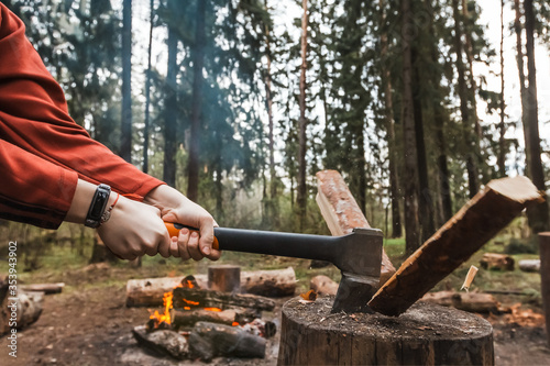 Canvastavla Female strong hands chop firewood with axe for bonfire