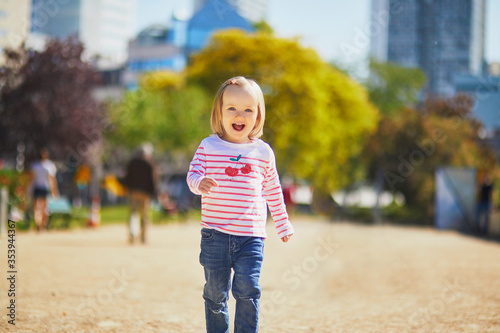 Cheerful toddler girl running on a street of Paris, France © Ekaterina Pokrovsky