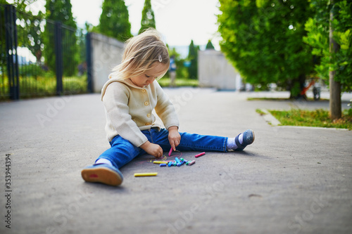 Adorable toddler girl drawing with colorful chalks © Ekaterina Pokrovsky