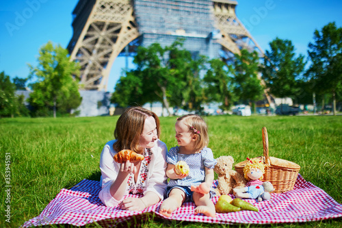 Photography Young woman with toddler girl having picnic near the Eiffel tower in Paris