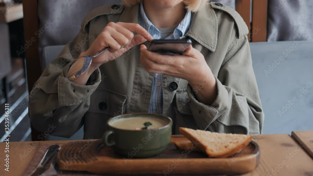 A woman hands using a smartphone camera to shoot a plate of soup in a restaurant A woman hands using a smartphone camera to shoot a plate of soup in a restaurant