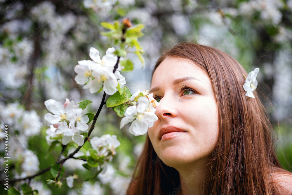 Portrait of a beautiful girl with long hair, in an Apple orchard. Spring garden. White flower. An Apple tree blooms in the Park. Model with beautiful hair. Portrait of a beautiful girl with long hair, in an Apple orchard. Spring garden. White flower. An Apple tree blooms in the Park. Model with beautiful hair.