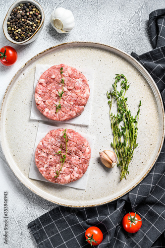 Raw pork patty, ground meat cutlets on a cutting Board. Organic mince. Gray background. Top view