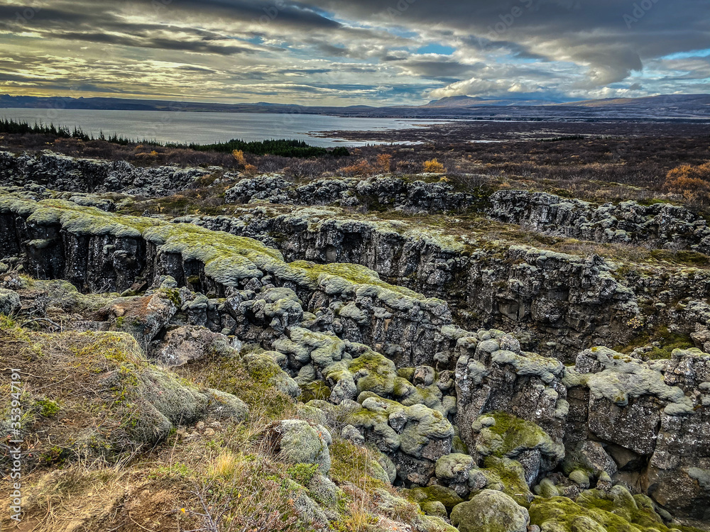 Dark clouds and a landscape with moss and cliffs in Iceland.